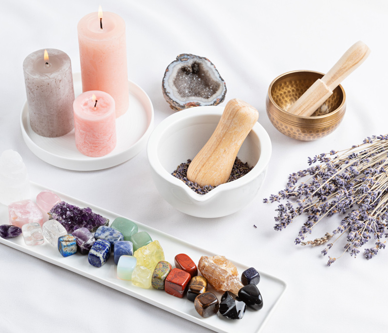 A colorful array of gemstones, candles, singing bowls, lavender.
